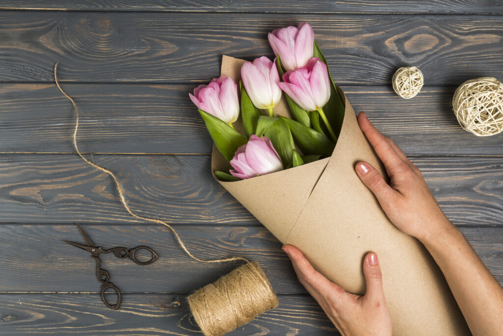 person-wrapping-bright-tulips-pack-paper